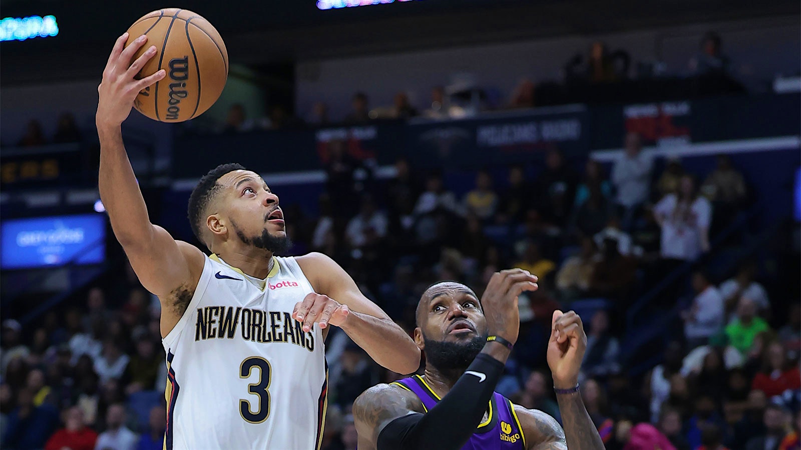 New Orleans Pelican C.J. McCollum shoots over Los Angeles Laker LeBron James.
